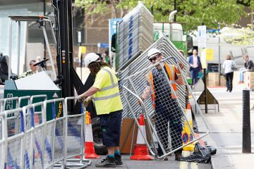 Construction workers erecting barriers Construction workers erecting barriers