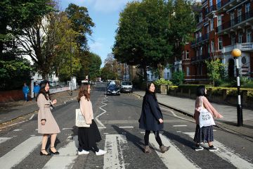 Chinese tourists walk across Abby Road in London, England, recreating the famous 1969 Beatles 'Abby Road' album cover photograph Chinese women walk across Abbey Road, London to illustrate Chinese women ‘see study as an escape’