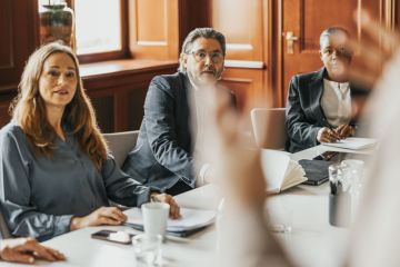 Board members listen to someone speaking