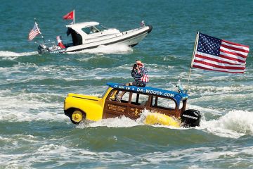 Man in boat shaped like a car with the American flag