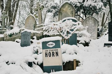 The gravestone of Jim Stanford Horn shaped like a book by Penguin Books publishing house is covered in snow at Highgate Cemetery on 12 December, 2022 in London, England. To illustrate that reading is dying out on UK campuses.