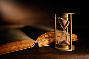 An old book next to an hourglass, symbolising English literature
