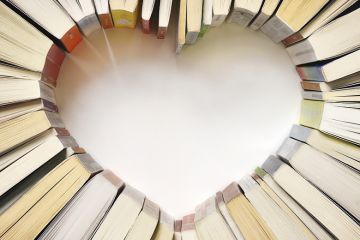 Books arranged on table in shape of heart