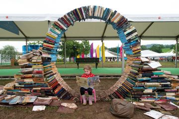 A girl reads a book during the Hay festival