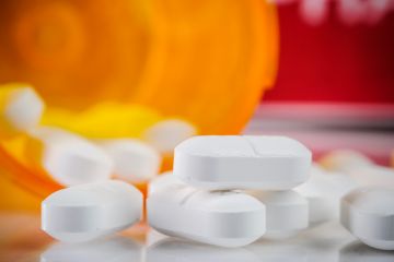 Bottle of pills spilled on surface Bottle of pills spilled on surface