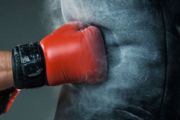Boxer's fist punching heavy bag