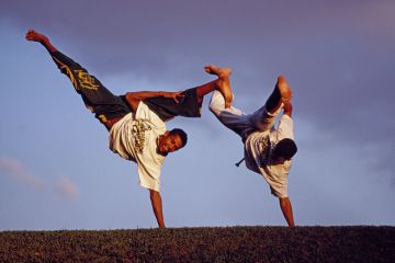 Brazilian men performing capoeira outdoors Brazilian men performing capoeira outdoors