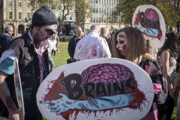 Bristol, United Kingdom - 28 October 2017 People dress up as zombies for the tenth Anniversary Bristol Zombie Walk and carry banners as part of halloween celebrations in Bristol, UK. Bristol, United Kingdom - 28 October 2017 People dress up as zombies for the tenth Anniversary Bristol Zombie Walk and carry banners as part of halloween celebrations in Bristol, UK.