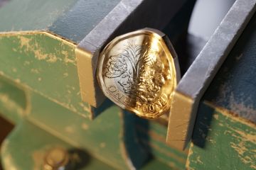 British pound coin held by a bench vice or clamp British pound coin held by a bench vice or clamp