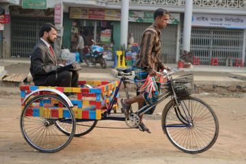 Businessman being transported on rickshaw Businessman being transported on rickshaw