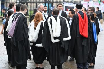 Cambridge, England, 30_November_2024, UK. Students gather on Kings Parade after attending graduation day at St Marys church along Kings Parade in Cambridge,