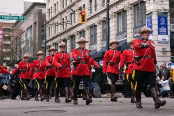 RCMP officers, dressed in ceremonial red serge, march through Vancouver for Remembrance Day Vancouver, BC, Canada – November 11, 2016: RCMP officers, dressed in ceremonial red serge, march through downtown Vancouver for Remembrance Day.