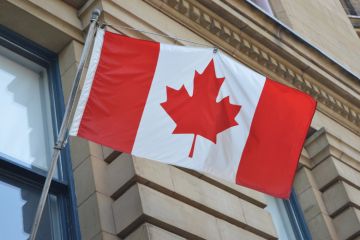 Canadian flag suspended outside building Canadian flag suspended outside building