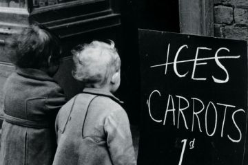 Small children looking at 'Carrots instead of ice lollies' sign
