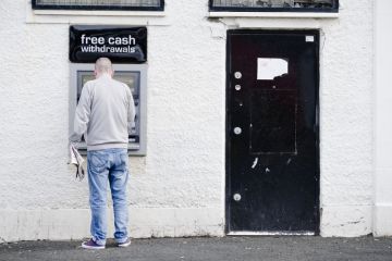 Govan, Glasgow / UK - August 31st 2019: Male person at cash point machine ATM automated free money withdrawal in wall