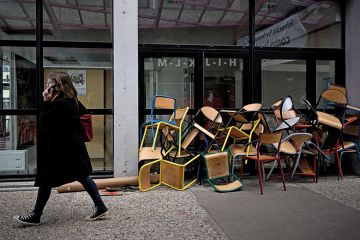 A student walks past a pile of chairs blocking a door of the Bordeaux Montaigne University, in Pessac A student walks past a pile of chairs blocking a door of the Bordeaux Montaigne University, in Pessac