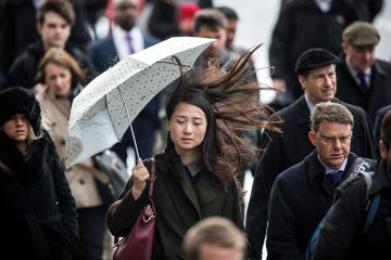 Asian woman holding umbrella on windy day Asian woman holding umbrella on windy day