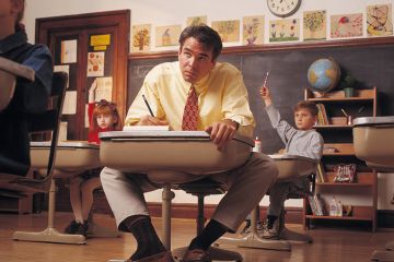 Man sits at child’s desk