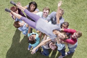 A group of people hold up a woman A group of people hold up a woman, symbolising collaboration