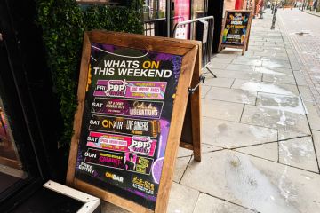 Colourful street sign outside a Manchester cafe promoting weekend events and drinks Colourful street sign outside a Manchester cafe promoting weekend events and drinks