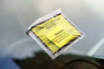 Coventry, UK - FEBRUARY 10, 2017 Generic penalty charge notice (parking fine) attached to windscreen of white car parked on street in Coventry, UK
