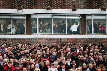 A busy crowd, with some in a hospitality area, at the races at Kempton Park in Sunbury, England. To illustrate a two tier workforce.