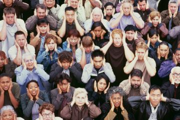 Crowd of people covering ears