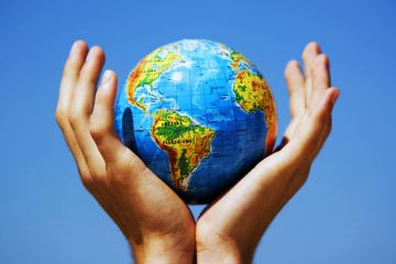 Cupped hands holding globe aloft