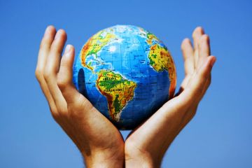 Cupped hands holding globe aloft Cupped hands holding globe aloft