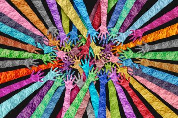 Multicololoured hands overlapping, symbolising DEI Multicololoured hands overlapping, symbolising DEI