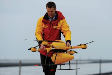DHL employee prepares PaketKopter drone for delivery DHL employee prepares PaketKopter drone for delivery