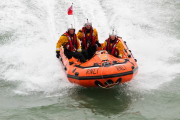 Eastbourne, UK - 17 August, 2013 Royal National Lifeboat Institution (RNLI) in-shore crew on duty at the Eastbourne Air Show on the English Channel, UK on 17 August, 2013. Eastbourne, UK - 17 August, 2013 Royal National Lifeboat Institution (RNLI) in-shore crew on duty at the Eastbourne Air Show on the English Channel, UK on 17 August, 2013.