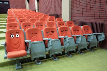 Emotive faces drawn on lecture hall chairs