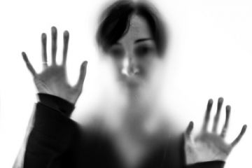 Shadowy woman figure behind frosted glass Shadowy woman figure behind frosted glass