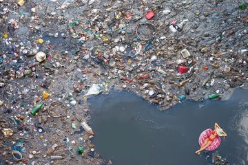 Montage of woman floating in sea of rubbish