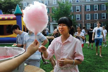 Female student buying cotton candy, Yale Summer School