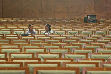 Female students chatting in empty lecture hall