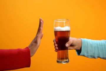 Female rejecting beer glass showing stop gesture Female rejecting beer glass showing stop gesture