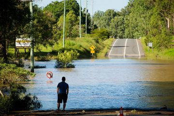 A stranded resident looks at a road, submerged under floodwaters in Queensland. To illustrate that domestic enrolments in Australian universities risk bypassing the areas of greatest need, as regional universities experience a decline in enrolments. A stranded resident looks at a road, submerged under floodwaters in Queensland. To illustrate that domestic enrolments in Australian universities risk bypassing the areas of greatest need, as regional universities experience a decline in enrolments.