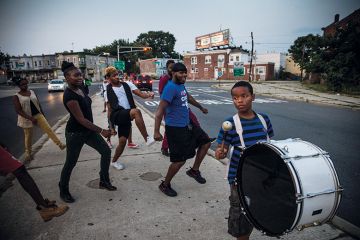 Children dancing in street, following a drummer