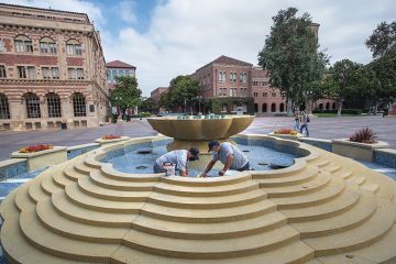 Men repair damaged tiles inside a fountain on the USC campus in Los Angeles Men repair damaged tiles inside a fountain on the USC campus in Los Angeles