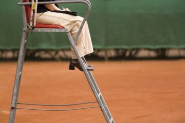 Female referee on a clay tennis court Female referee on a clay tennis court