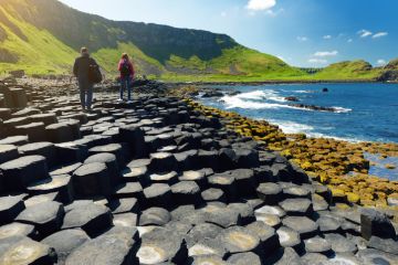 Two tourists walking at Giants Causeway Two tourists walking at Giants Causeway