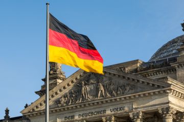 German flag fluttering in front of the Reichstag building in Berlin