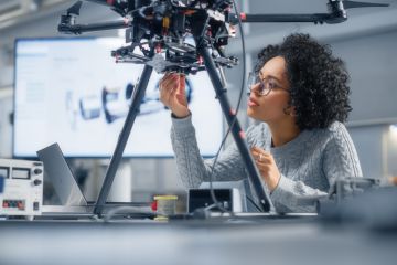 A black female engineer working on what appears to be a drone