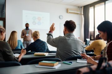 A man raises his hand in a classroom 