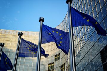 Several EU flags in front of the European Commission building in Brussels