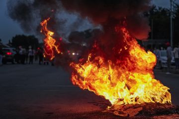Burning tyres smolder on a road during a protest action, Burning tyres smolder on a road during a protest action,
