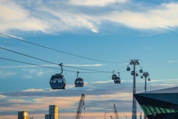 Modern Cable Car System Soaring Above the City Skyline at Sunset in Greenwich, London Modern Cable Car System Soaring Above the City Skyline at Sunset in Greenwich, London