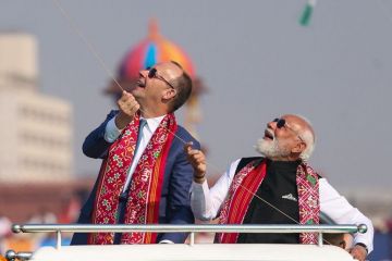 Indian Prime Minister Narendra Modi and German Chancellor Friedrich Merz fly kites during the International Kite Festival